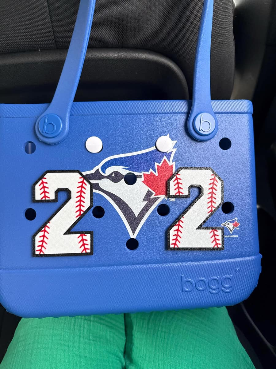Blue Bogg Bag with two baseball-stitch number 2 charms on either side of a team logo
