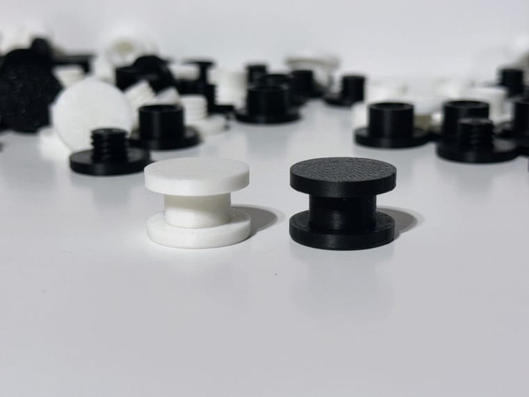 3D printed DIY Bogg Bag charm backers in white and black, flatlay