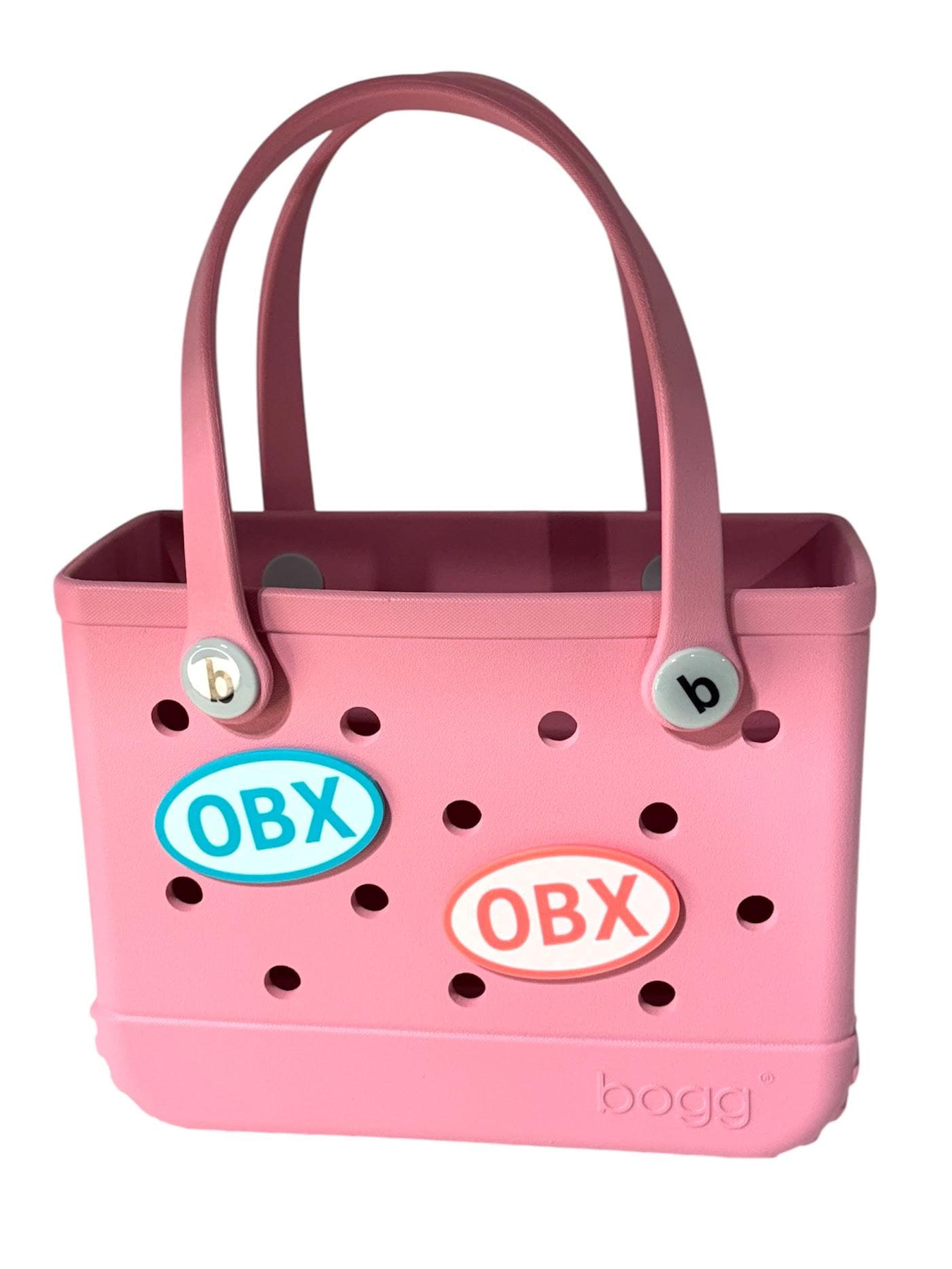 OBX charm attached to a blue Bogg Bag at the beach, lifestyle photo